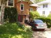 The back of the house, with a car on the path to the back door.
